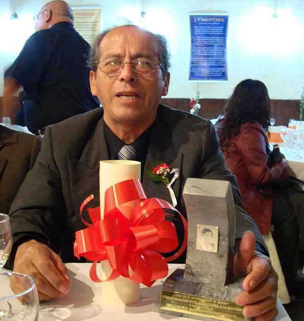 El Presidente de la Casa de la Cultura "Mar�a de Nazaret", con los premios a otorgar al poeta Eliseo Le�n Pretell.